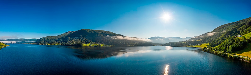 Ruhiger See inmitten von Bergen unter klarem Himmel, Sinnbild für innere Ruhe, Balance und Klarheit bei wichtigen Entscheidungen
