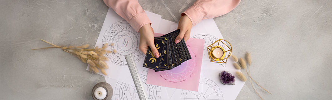 Tarotkarten werden auf einem astrologischen Untergrund gelegt, Symbol für intuitive Deutung, Wahrsagung und persönliche spirituelle Beratung