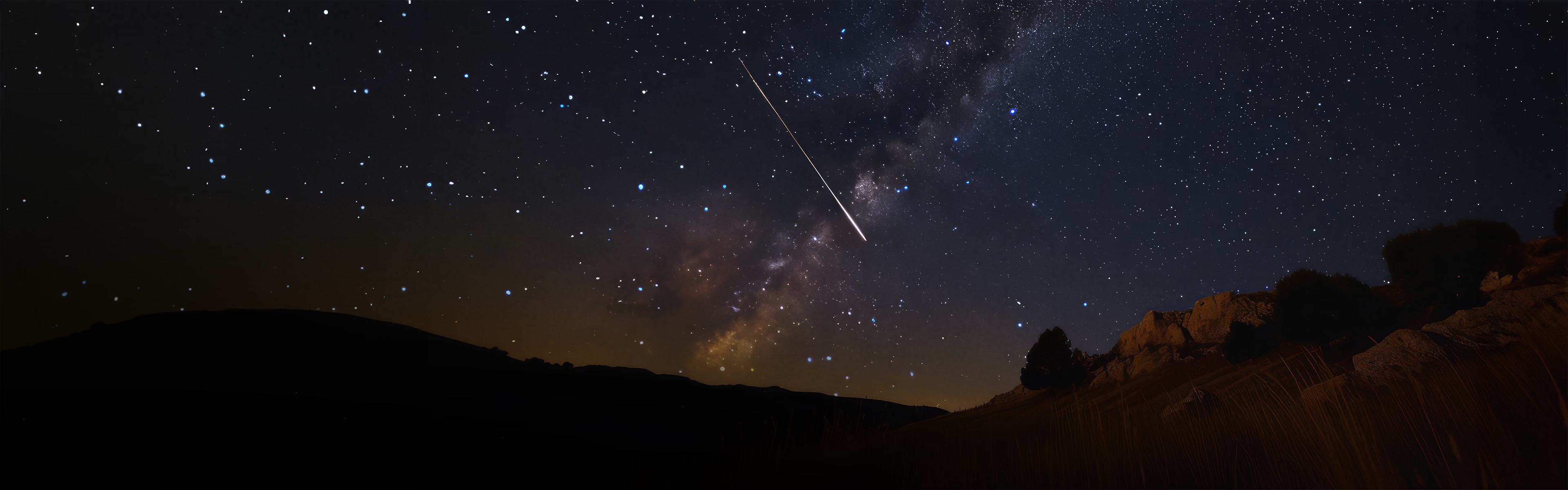 Sternenklarer Nachthimmel mit einer Sternschnuppe über einer felsigen Landschaft – stimmungsvolle Illustration für einen Promotion-Banner rund um Astrologie und kosmische Energien.